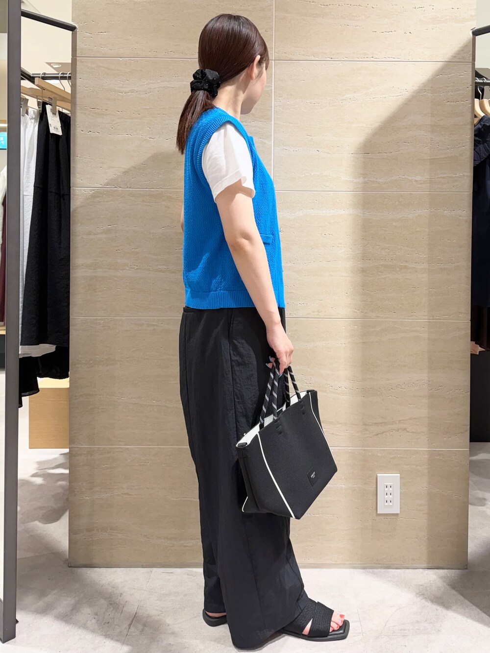 ブルー系のニット/セーター、ブラック系のその他パンツ、ブラック系のトートバッグを着用したレディースの夏コーディネートの3枚目の写真