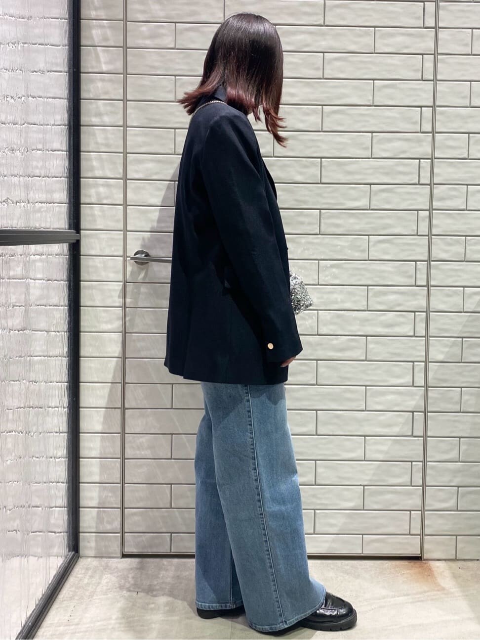 ブルー系のテーラードジャケット、ホワイト系のTシャツ/カットソー、ブルー系のデニムパンツを着用したレディースの冬コーディネートの3枚目の写真