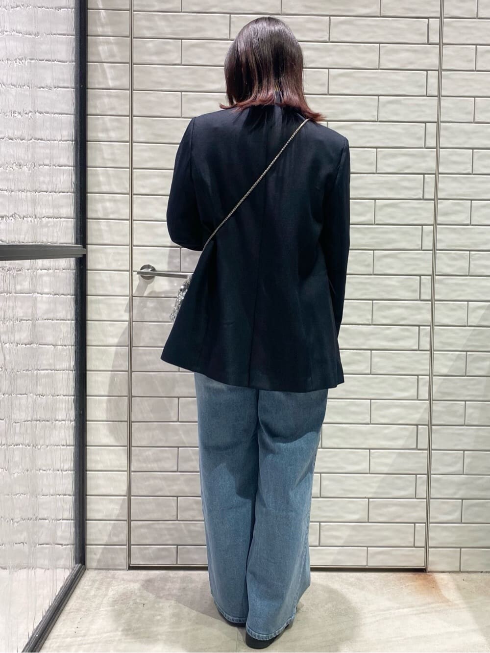 ブルー系のテーラードジャケット、ホワイト系のTシャツ/カットソー、ブルー系のデニムパンツを着用したレディースの冬コーディネートの2枚目の写真