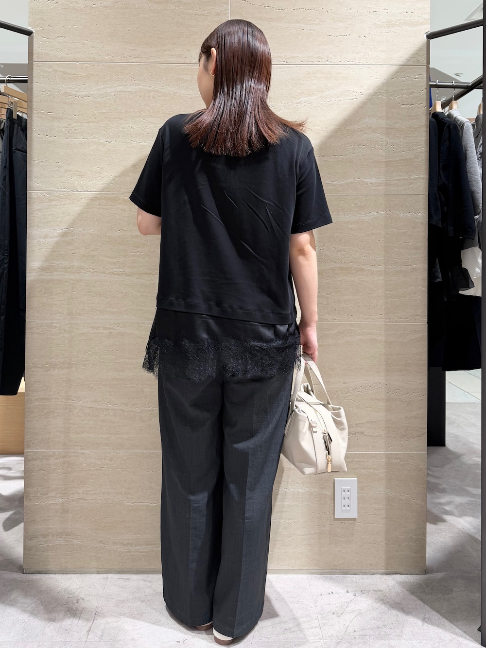 ブラック系のTシャツ/カットソー、グレー系のその他パンツ、ベージュ系のボストンバッグを着用したレディースの夏コーディネートの2枚目の写真