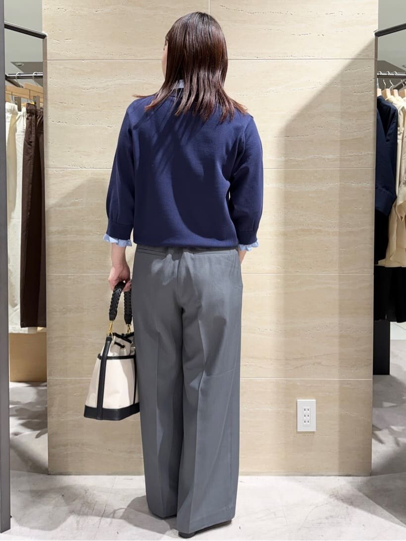 ブルー系のニット/セーター、グレー系のその他パンツ、ブラック系のショルダーバッグを着用したレディースの春コーディネートの2枚目の写真