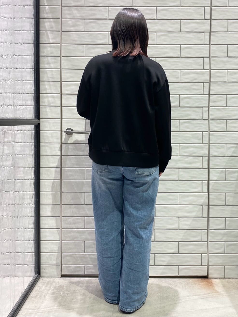 ブラック系のカーディガン/ボレロ、ホワイト系のTシャツ/カットソー、ブルー系のデニムパンツを着用したレディースの冬コーディネートの2枚目の写真