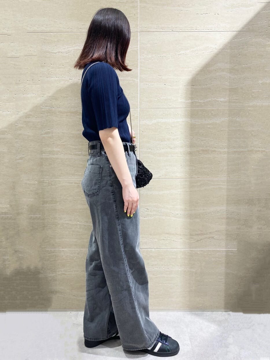 ブルー系のニット/セーター、グレー系のデニムパンツ、ブラック系のショルダーバッグを着用したレディースの春コーディネートの3枚目の写真