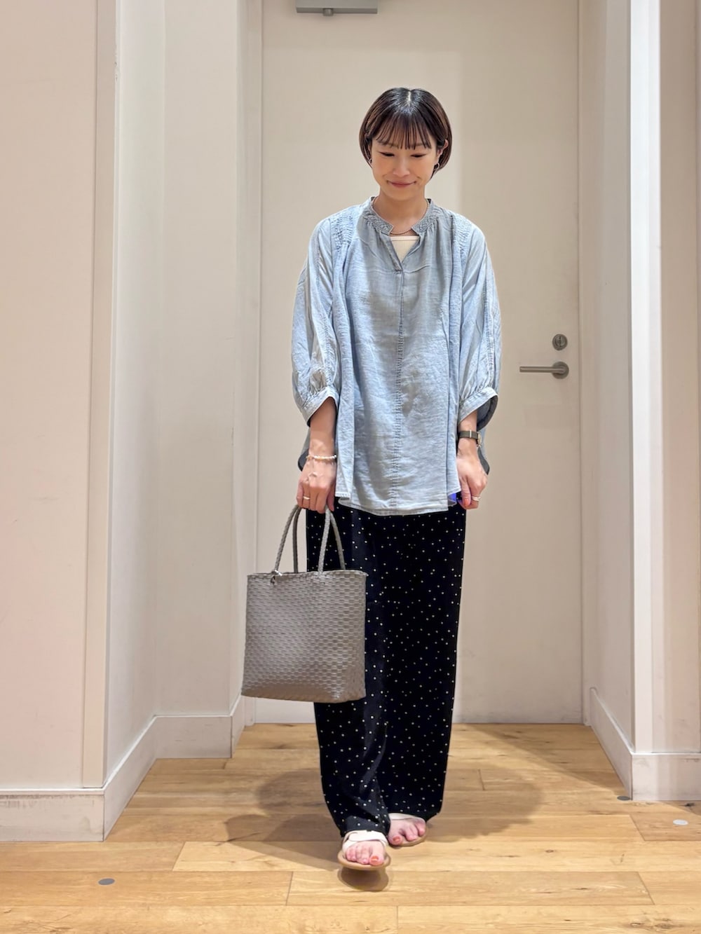 ブラック系のその他パンツ、グレー系のかごバッグ、ホワイト系のサンダルを着用したレディースの夏コーディネートの3枚目の写真