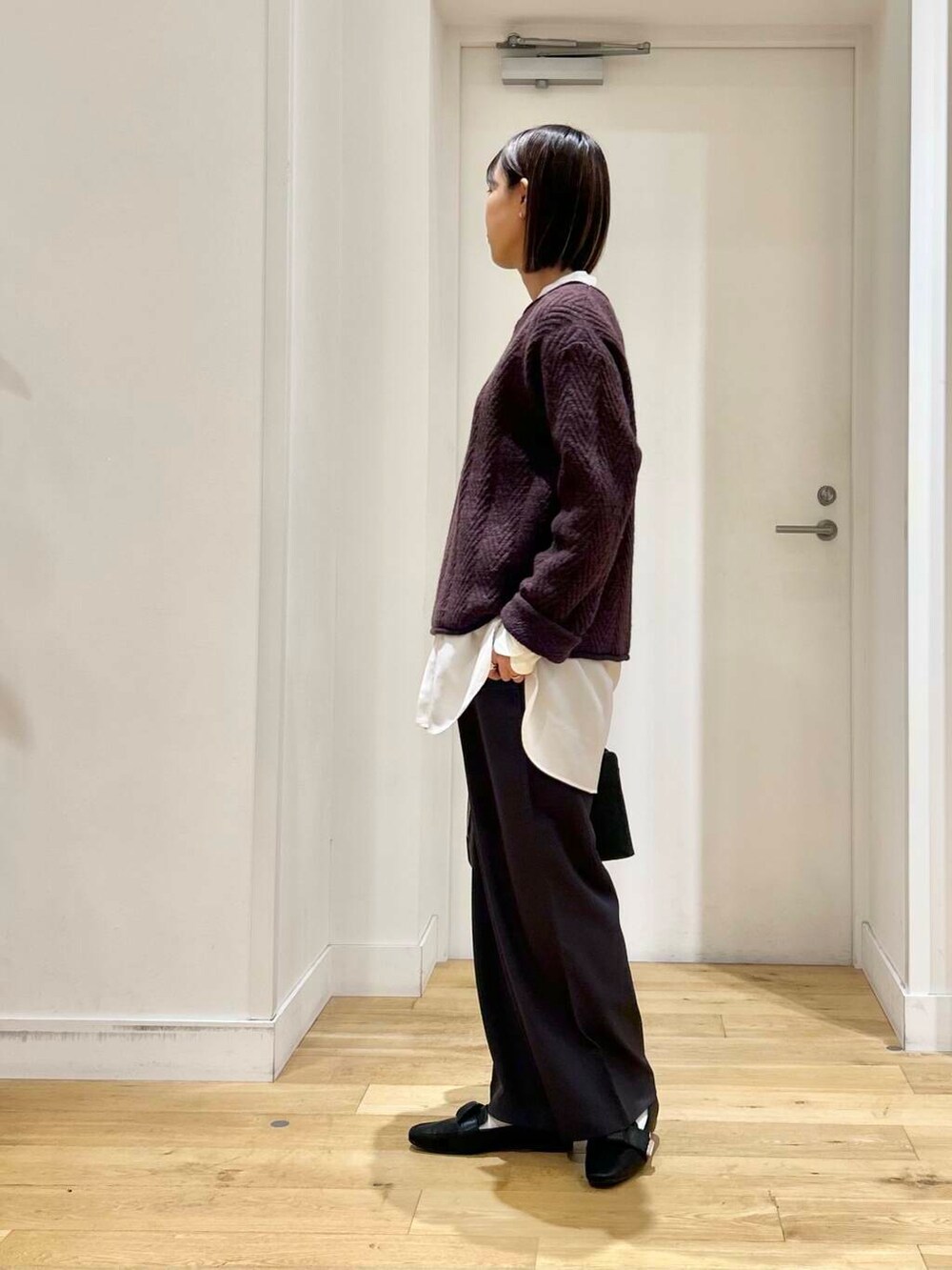 ブラック系のドレスシューズ、ホワイト系のシャツ/ブラウス、ブラック系のハンドバッグを着用したレディースの冬コーディネートの5枚目の写真