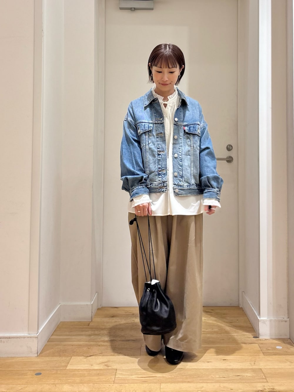 ホワイト系のシャツ/ブラウス、ブルー系のデニムジャケット、ベージュ系のその他パンツを着用したレディースの秋コーディネートの3枚目の写真