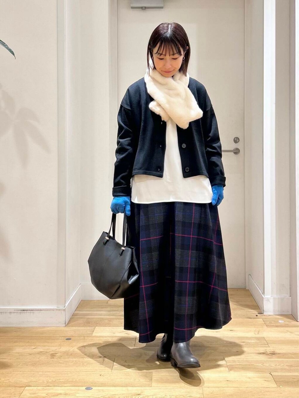 ブラック系のショルダーバッグ、グレー系のブーツ、ブラック系のカーディガン/ボレロを着用したレディースの秋コーディネートの3枚目の写真