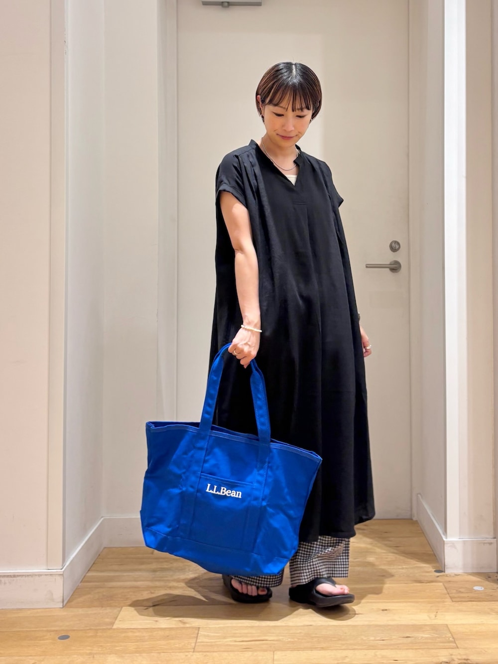 ブラック系のその他パンツ、ブラック系のサンダル、ホワイト系のタンクトップを着用したレディースの夏コーディネートの5枚目の写真
