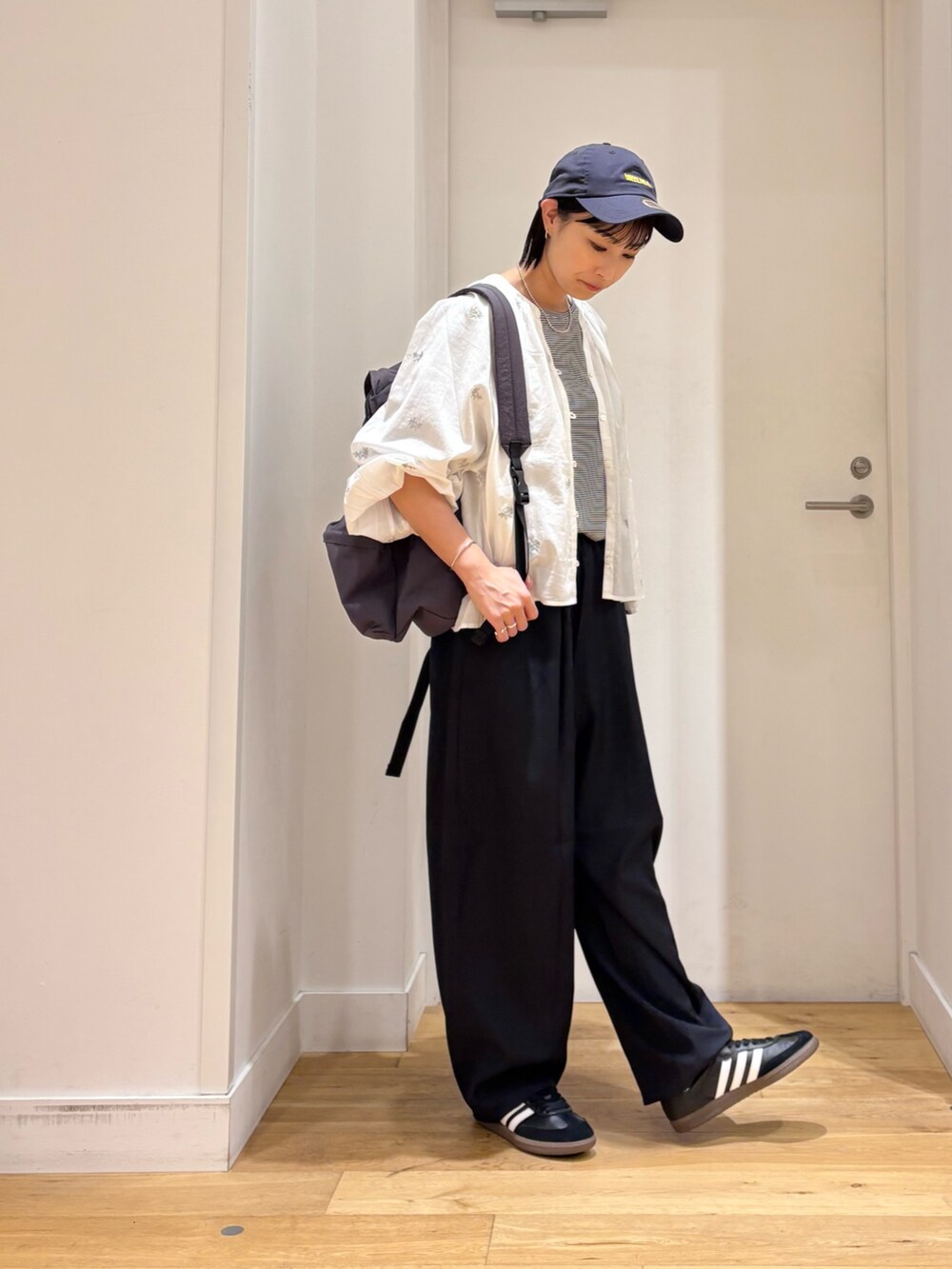 グレー系のバックパック/リュック、ホワイト系のシャツ/ブラウス、ブルー系のその他パンツを着用したレディースの秋コーディネートの5枚目の写真