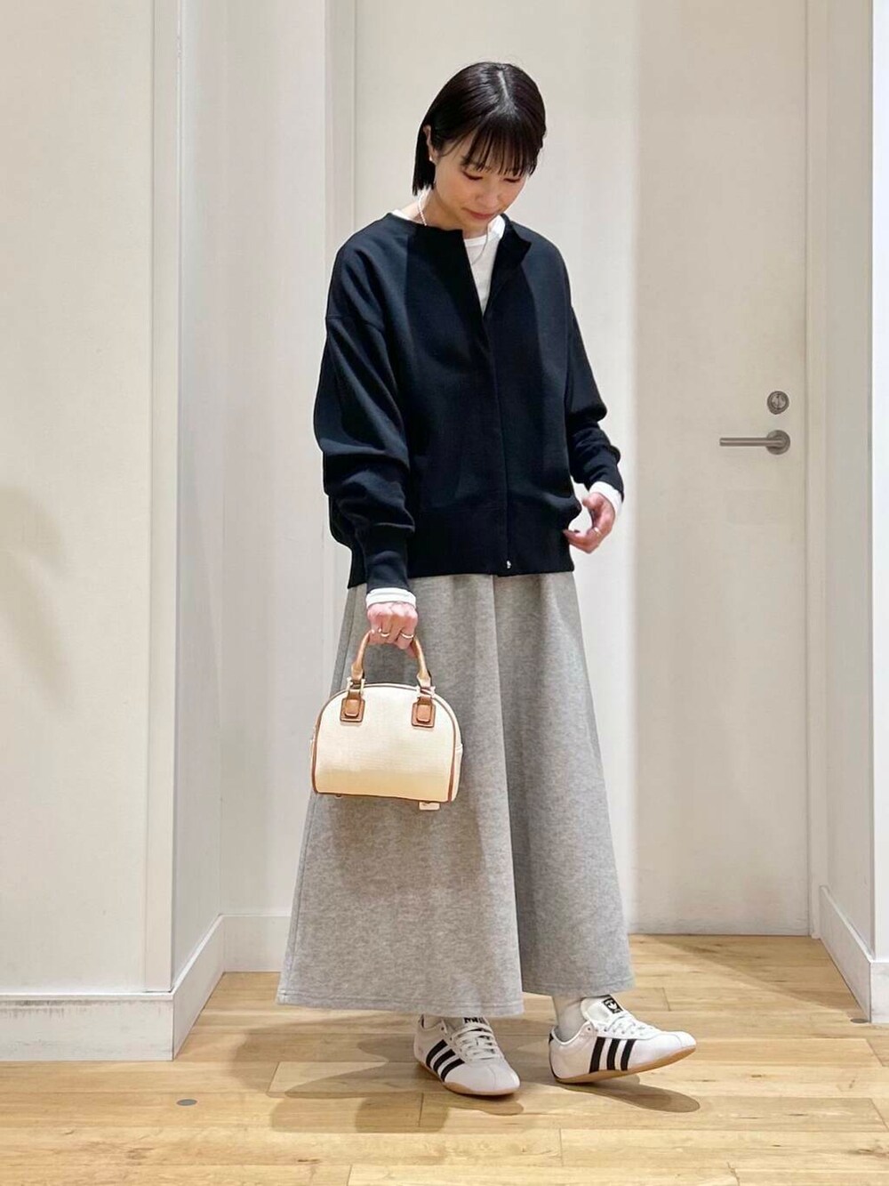 ホワイト系のTシャツ/カットソー、グレー系のスカート、ホワイト系のスニーカーを着用したレディースの冬コーディネートの3枚目の写真