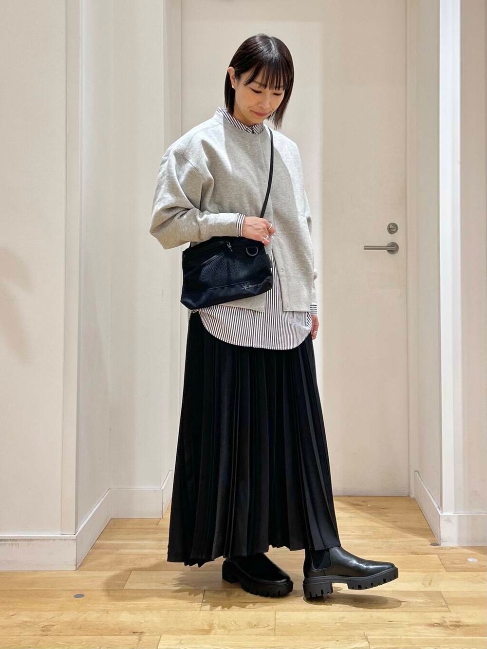 ブルー系のシャツ/ブラウス、ブラック系のブーツ、ブラック系のショルダーバッグを着用したレディースの冬コーディネートの4枚目の写真