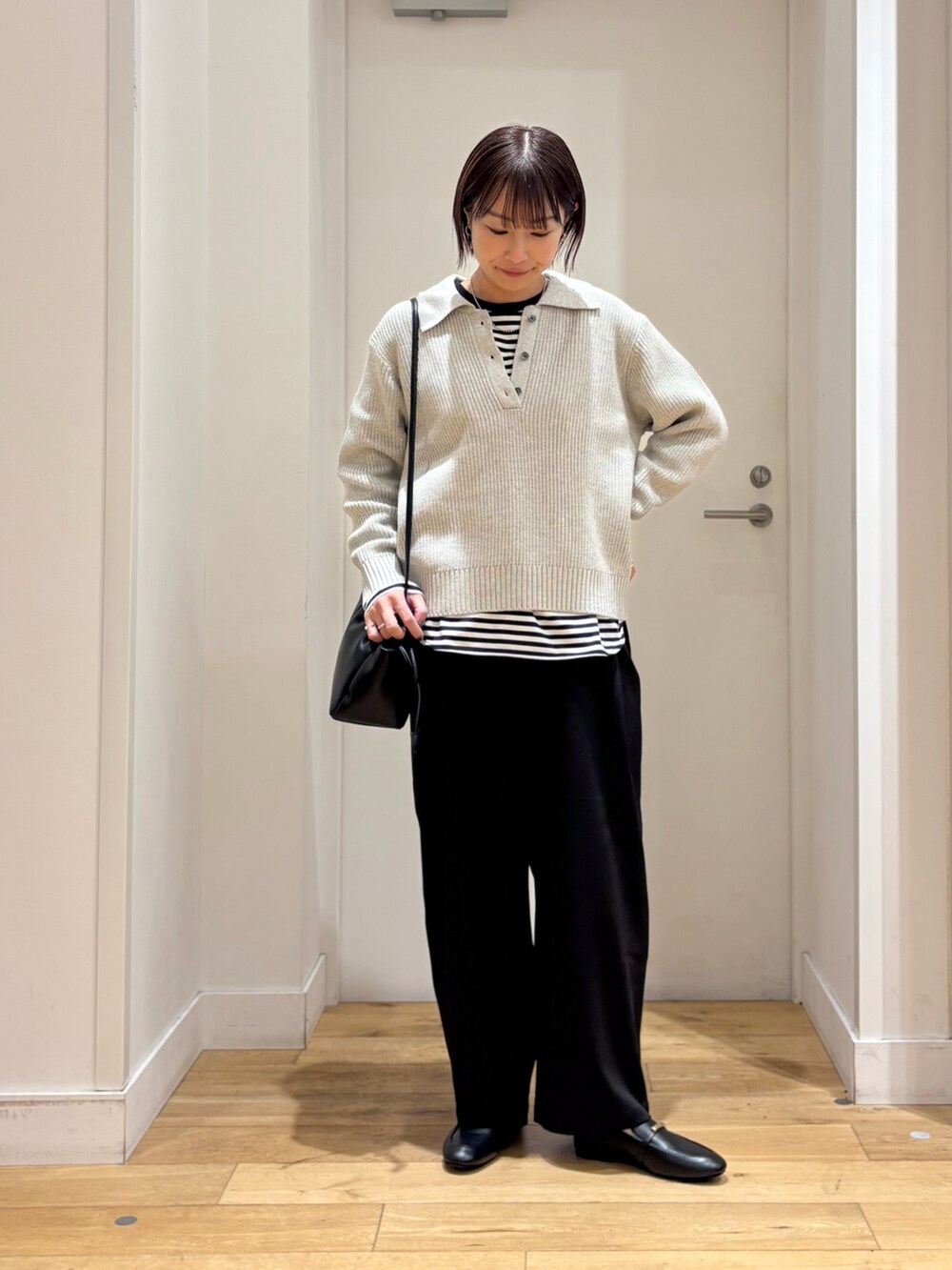 グレー系のニット/セーター、ホワイト系のTシャツ/カットソー、ブラック系のその他パンツを着用したレディースの冬コーディネートの3枚目の写真