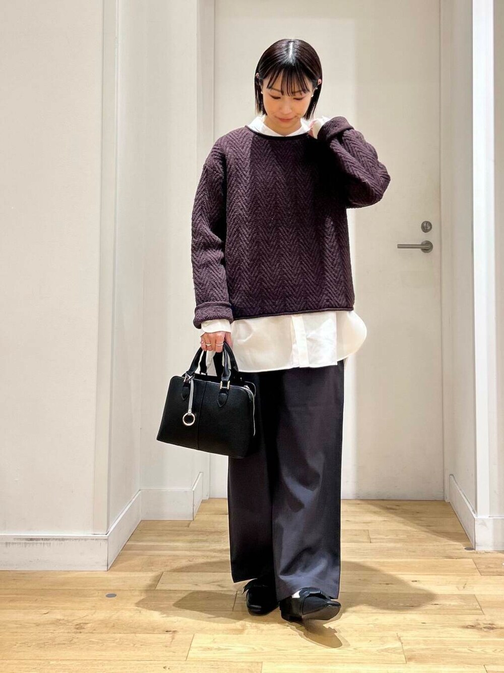 ブラック系のドレスシューズ、ホワイト系のシャツ/ブラウス、ブラック系のハンドバッグを着用したレディースの冬コーディネートの2枚目の写真