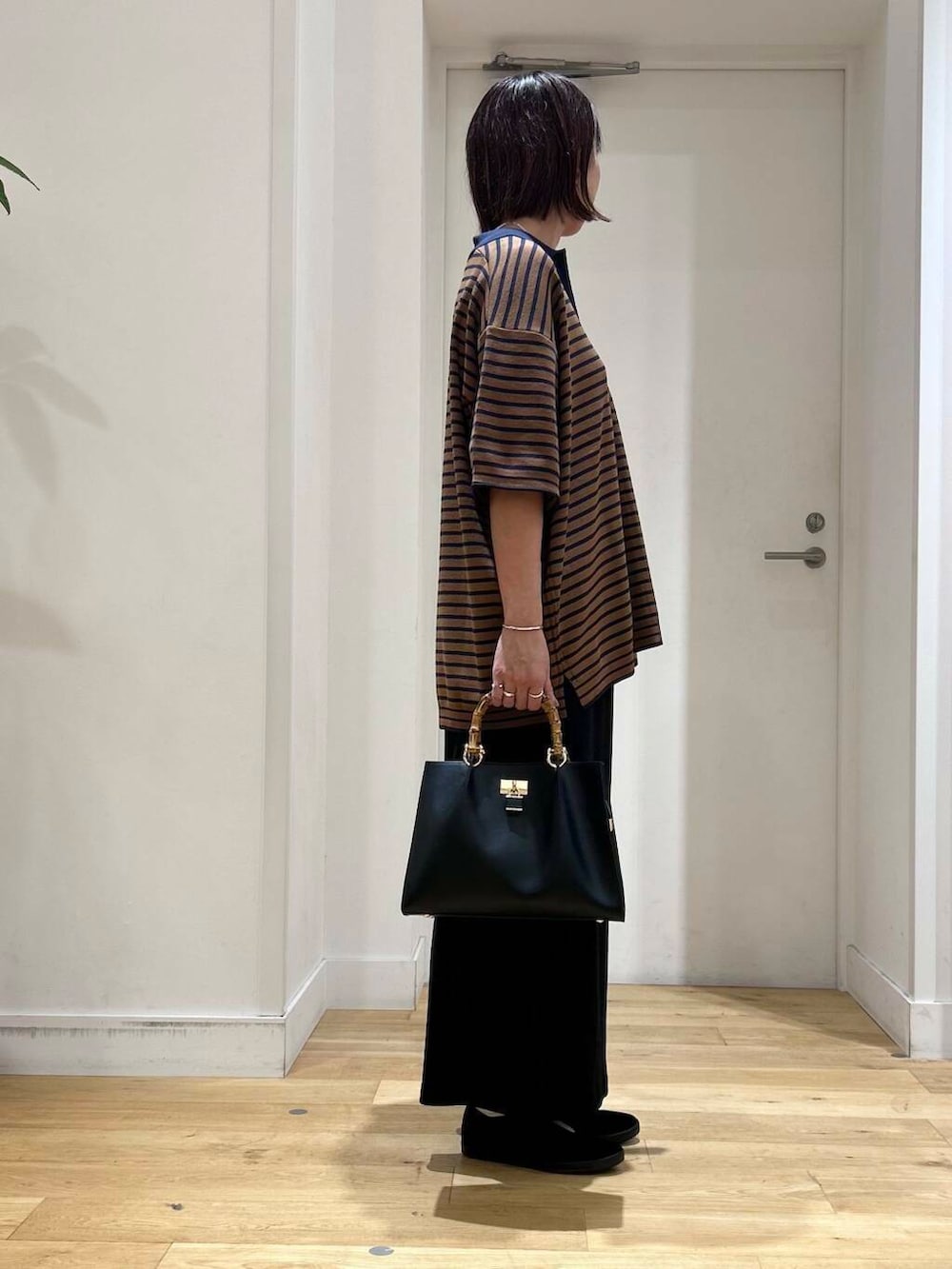 ブラック系のその他シューズ、ブラック系のスカート、ブラック系のハンドバッグを着用したレディースの夏コーディネートの3枚目の写真