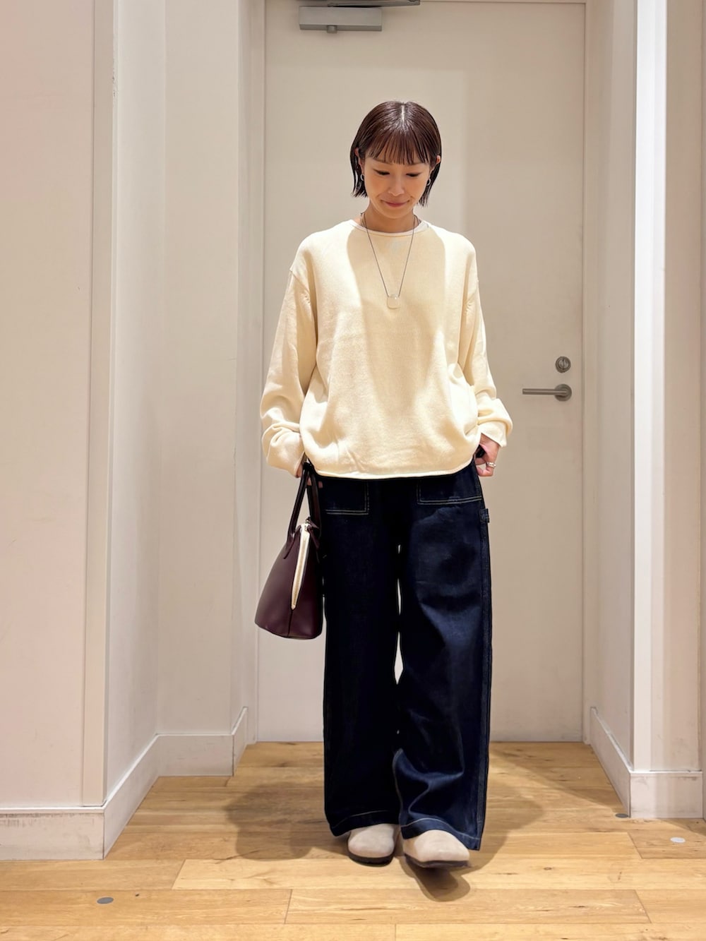 ホワイト系のニット/セーター、ブルー系のデニムパンツ、ベージュ系のその他シューズを着用したレディースの秋コーディネートの2枚目の写真