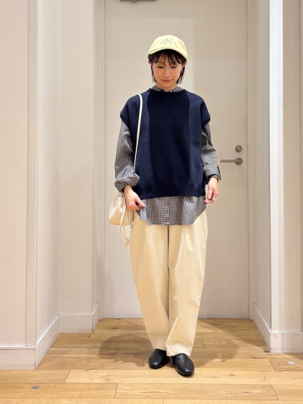 ブラック系のシャツ/ブラウス、ブルー系のベスト、ホワイト系のその他パンツを着用したレディースの冬コーディネートの3枚目の写真