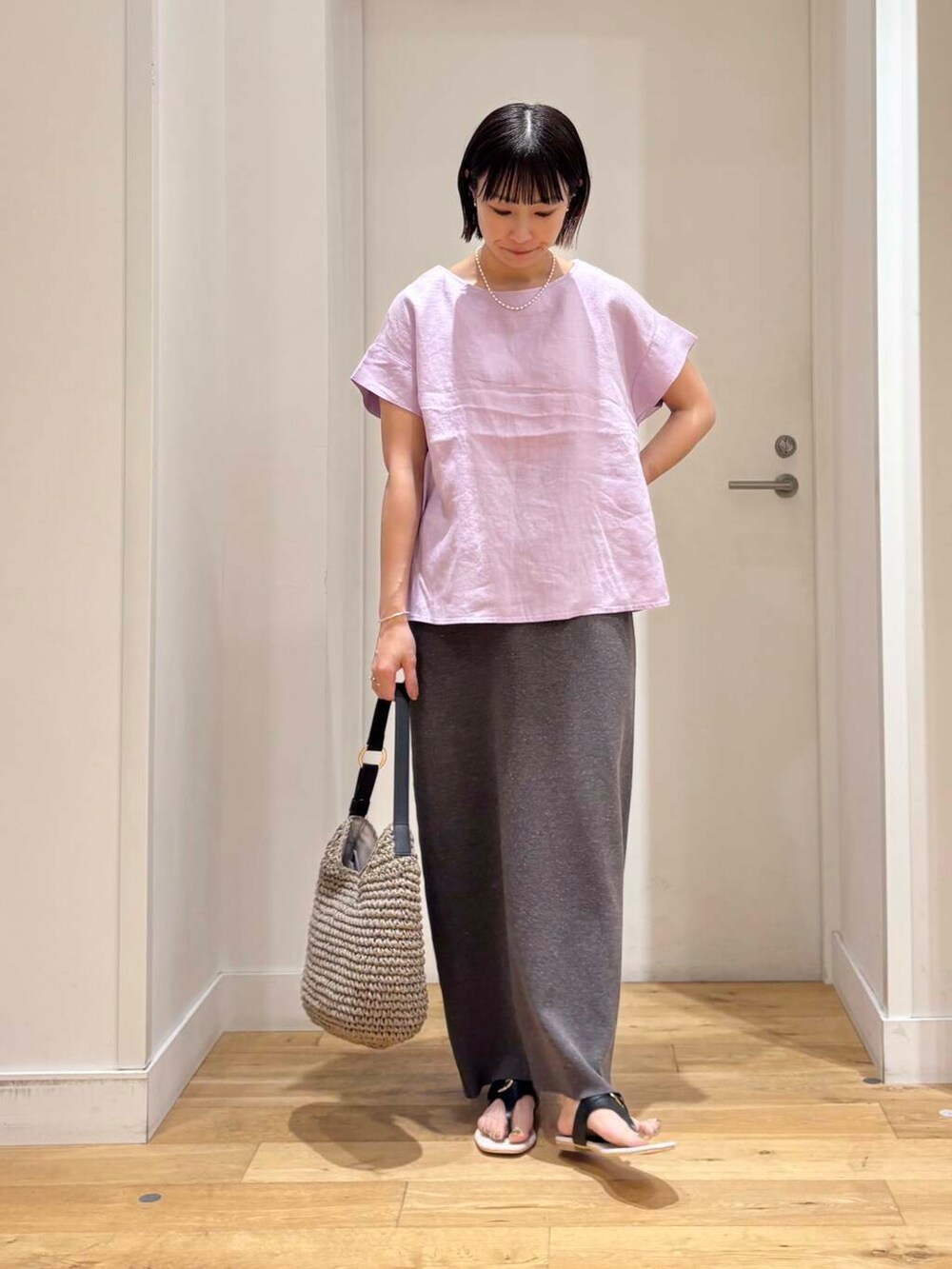 グレー系のトートバッグ、ブラック系のサンダル、グレー系のスカートを着用したレディースの夏コーディネートの3枚目の写真