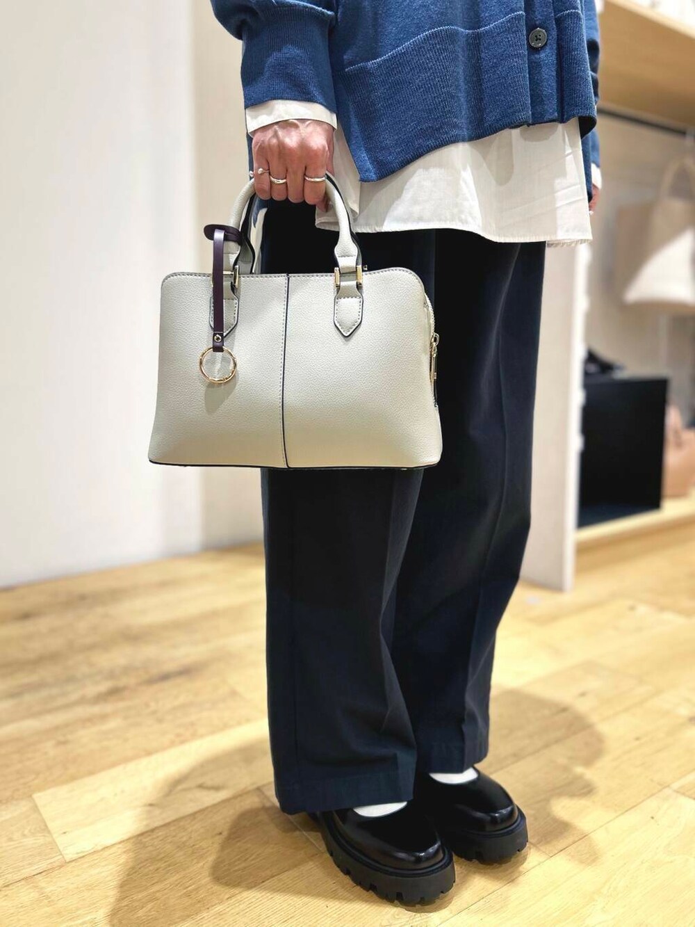 ブルー系のカーディガン/ボレロ、ホワイト系のシャツ/ブラウス、グレー系のハンドバッグを着用したレディースの秋コーディネートの7枚目の写真