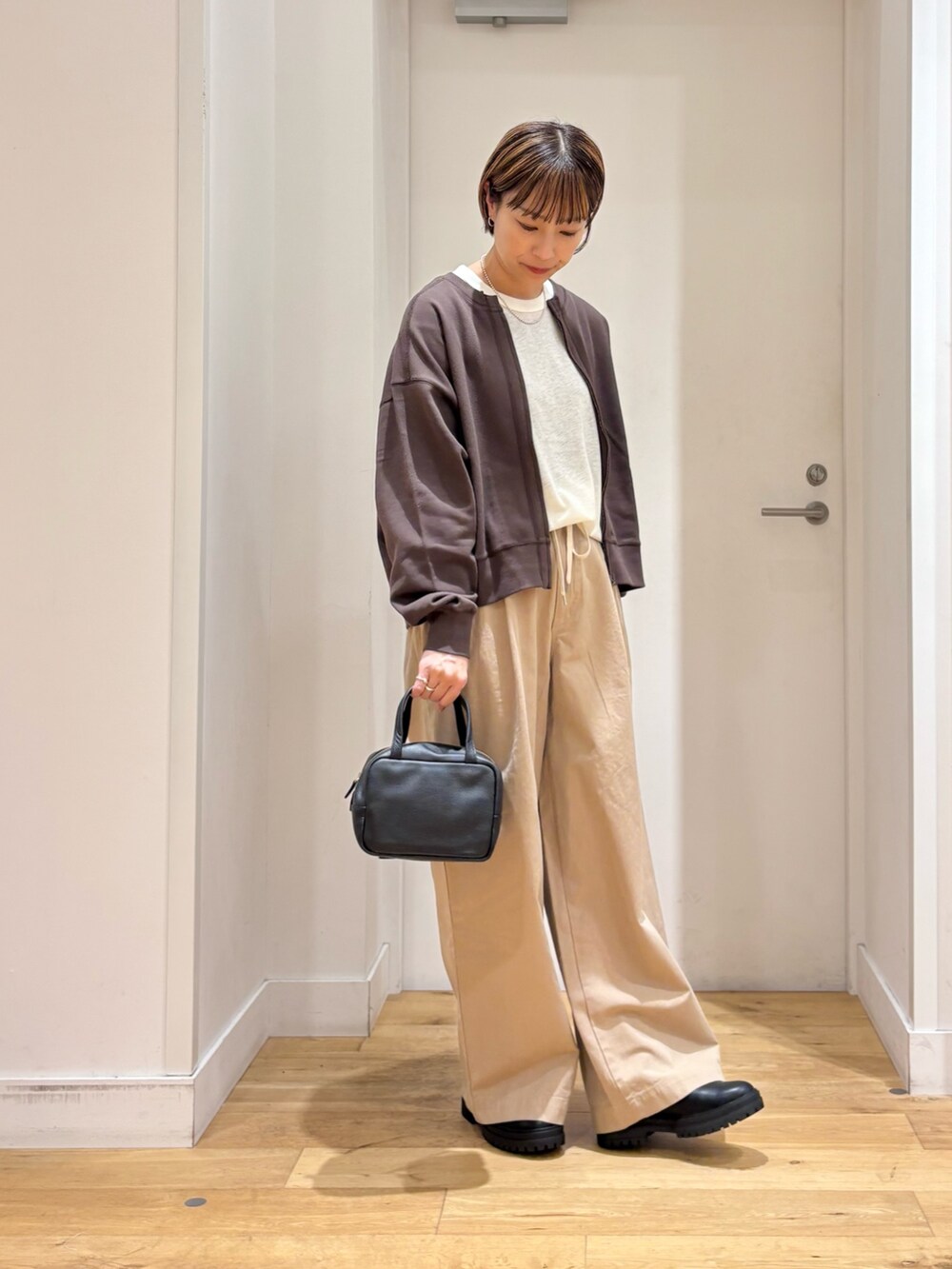 ベージュ系のその他パンツ、ホワイト系のTシャツ/カットソー、ブラウン系のカーディガン/ボレロを着用したレディースの秋コーディネートの5枚目の写真