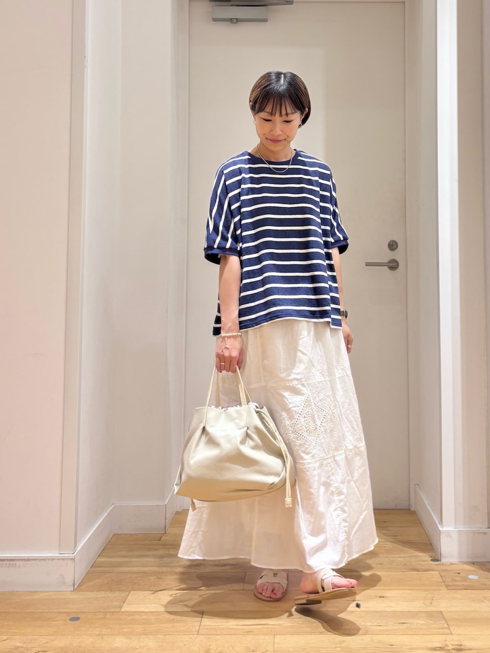 ブルー系のTシャツ/カットソー、ホワイト系のスカート、ホワイト系のショルダーバッグを着用したレディースの夏コーディネートの3枚目の写真