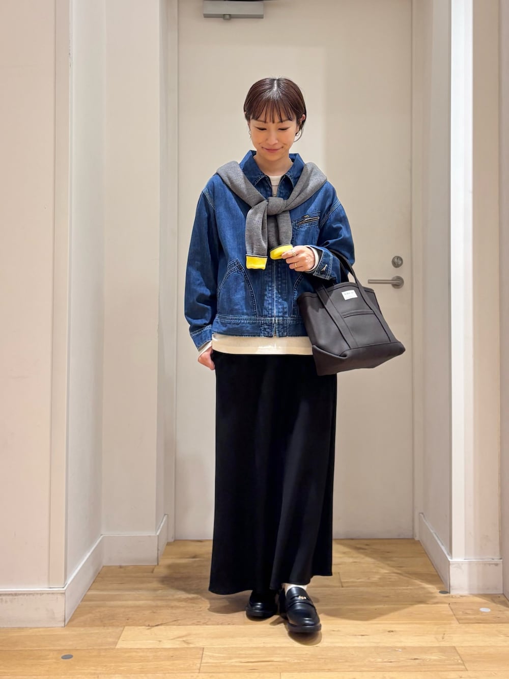 グレー系のカーディガン/ボレロ、ブルー系のデニムジャケット、ブラック系のローファーを着用したレディースの秋コーディネートの2枚目の写真