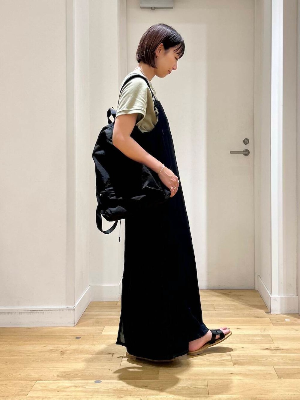 ブラック系のサンダル、ブルー系のワンピース、ブラック系のバックパック/リュックを着用したレディースの夏コーディネートの4枚目の写真