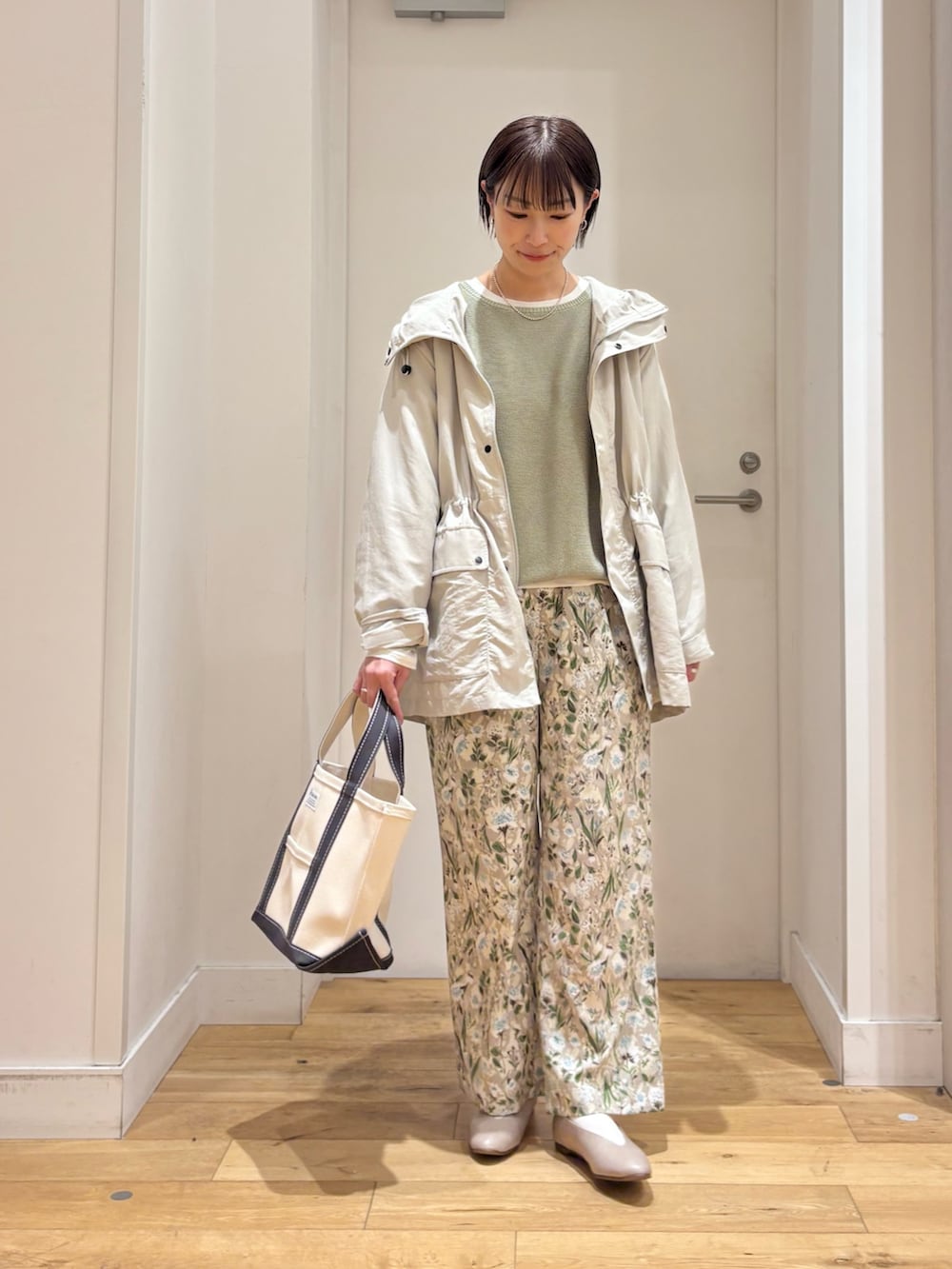 ベージュ系のマウンテンパーカー、グリーン系のニット/セーター、グレー系のパンプスを着用したレディースの春コーディネートの5枚目の写真