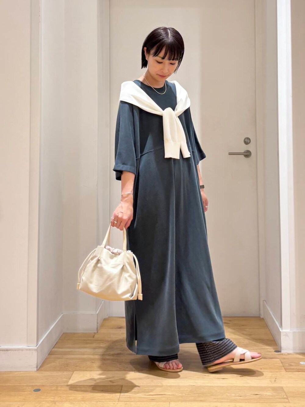 ホワイト系のサンダル、ホワイト系のカーディガン/ボレロ、グレー系のその他パンツを着用したレディースの夏コーディネートの3枚目の写真