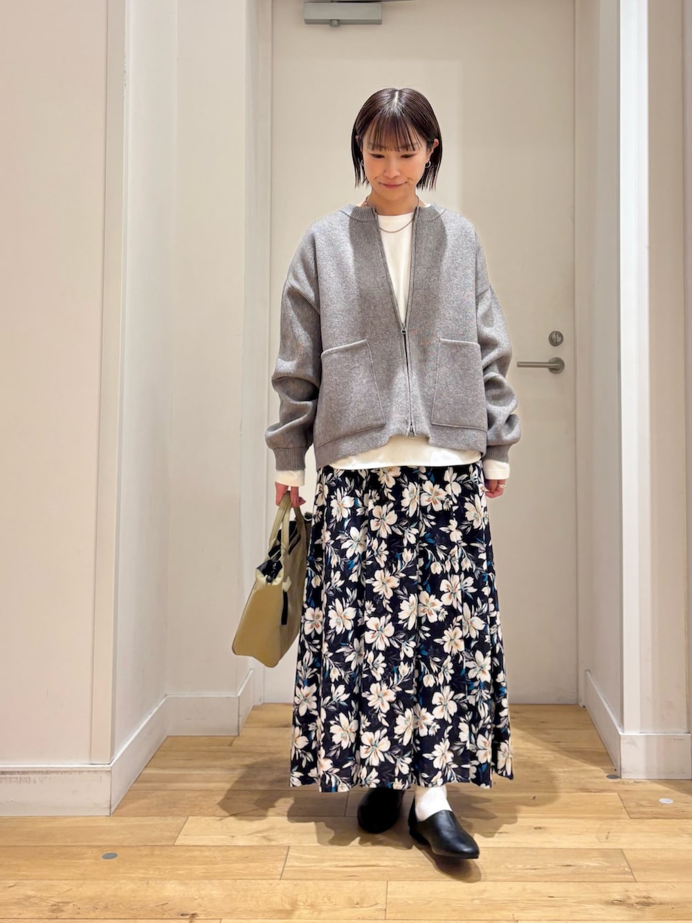 グリーン系のニット/セーター、ホワイト系のTシャツ/カットソー、ブルー系のスカートを着用したレディースの冬コーディネートの2枚目の写真