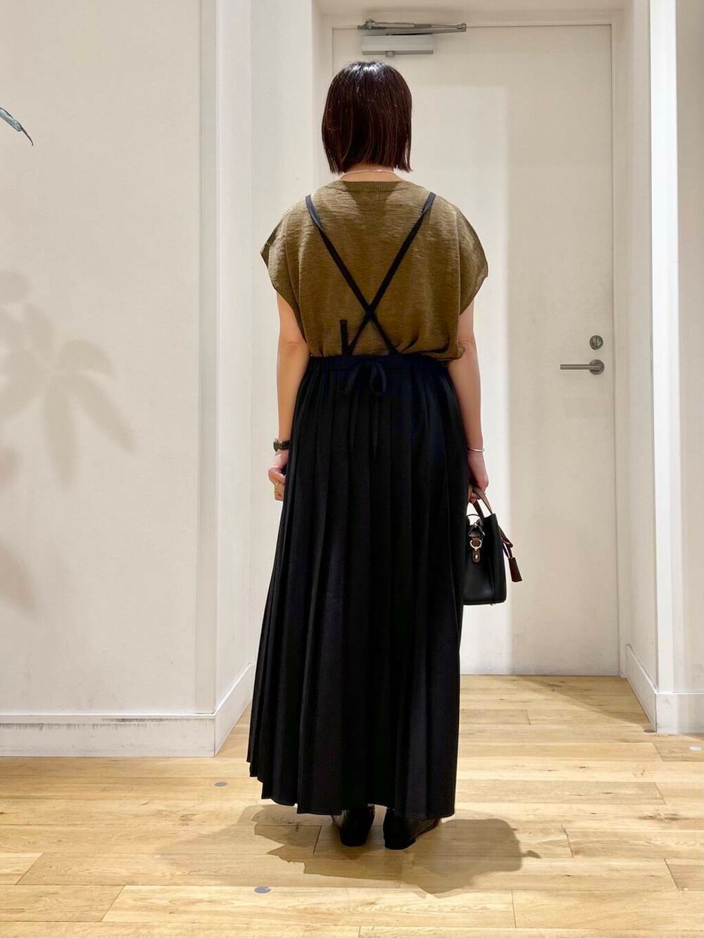 ブラック系のローファー、ブラック系のハンドバッグ、ブラウン系のニット/セーターを着用したレディースの夏コーディネートの5枚目の写真