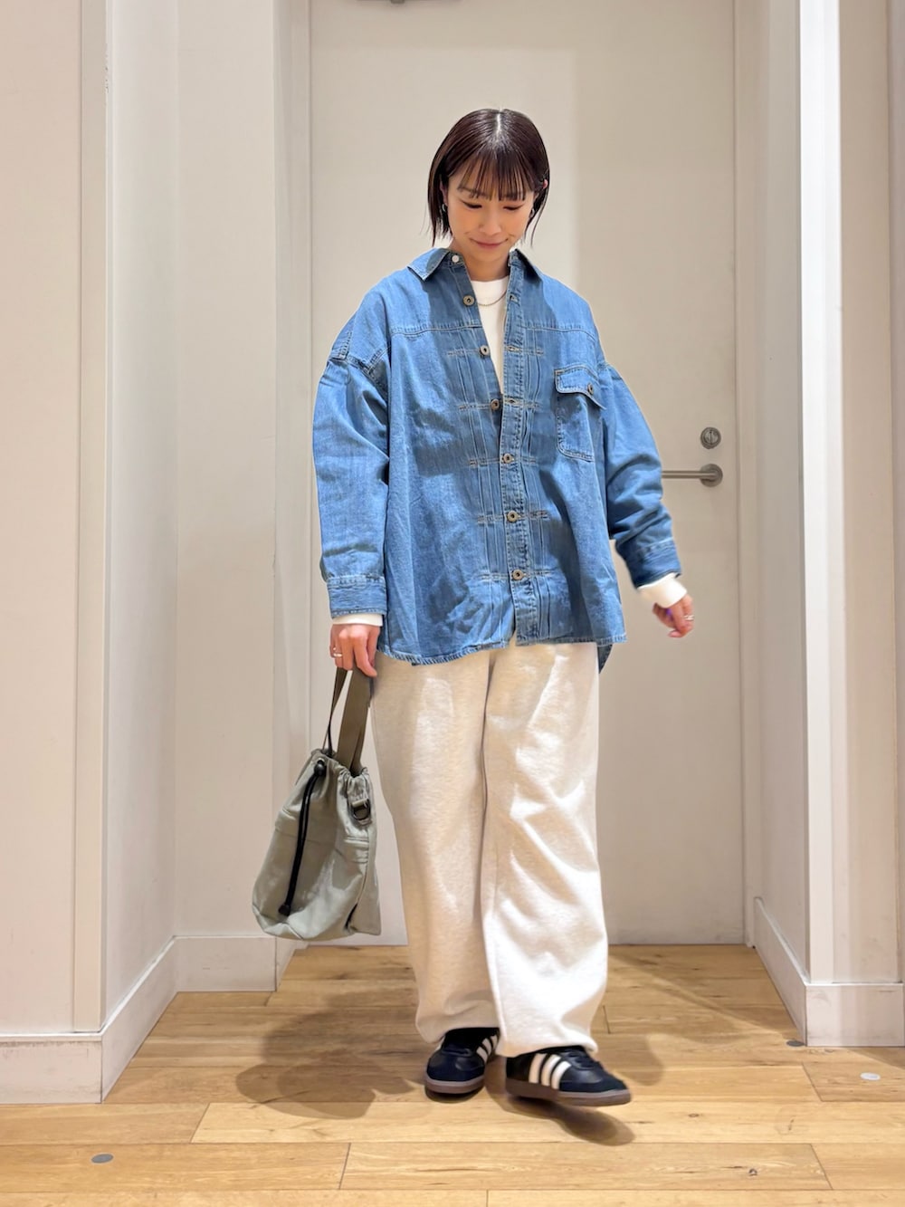 グレー系のその他パンツ、ブルー系のショルダーバッグ、ブラック系のスニーカーを着用したレディースの冬コーディネートの4枚目の写真