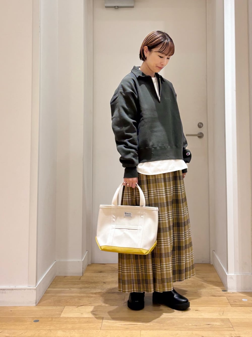 グリーン系のスウェット、イエロー系のスカート、ホワイト系のTシャツ/カットソーを着用したレディースの秋コーディネートの4枚目の写真