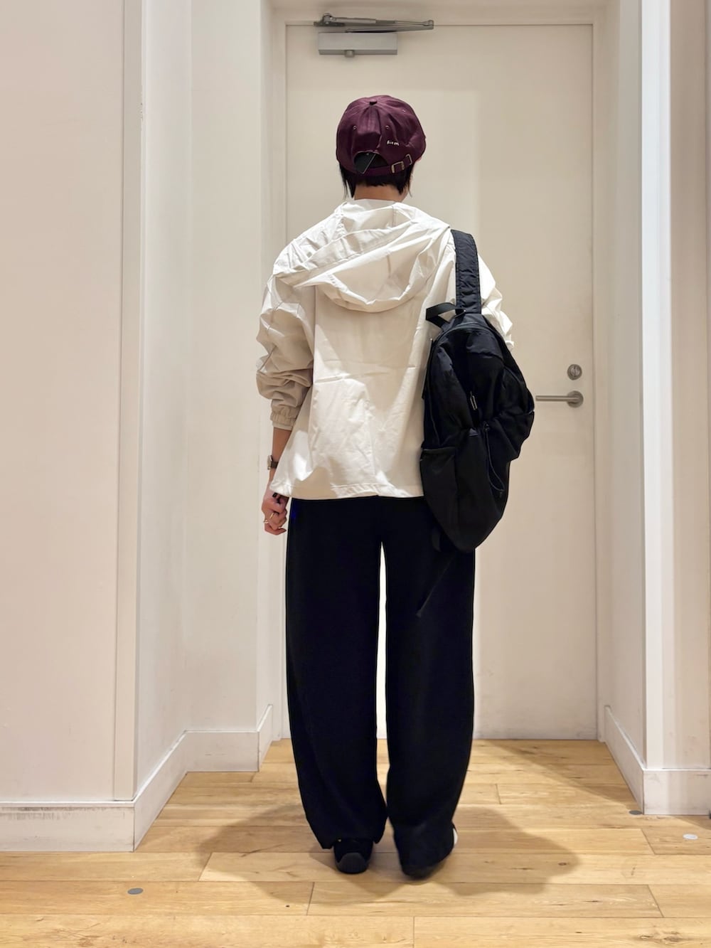 ホワイト系のナイロンジャケット、ブラック系のその他パンツ、ブラック系のスニーカーを着用したレディースの春コーディネートの7枚目の写真
