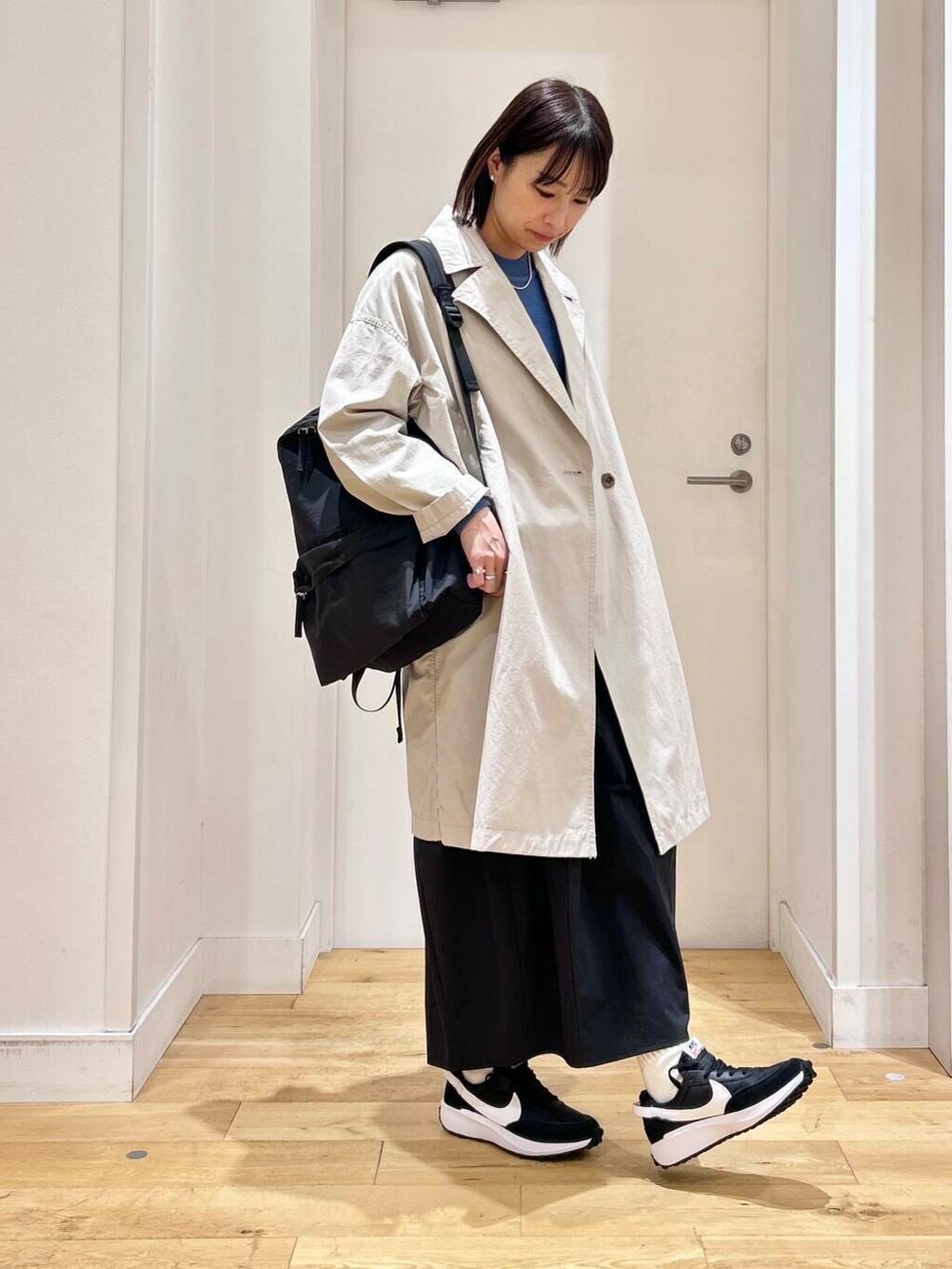 ブルー系のニット/セーター、ブラック系のバックパック/リュック、ベージュ系のその他アウターを着用したレディースの冬コーディネートの4枚目の写真