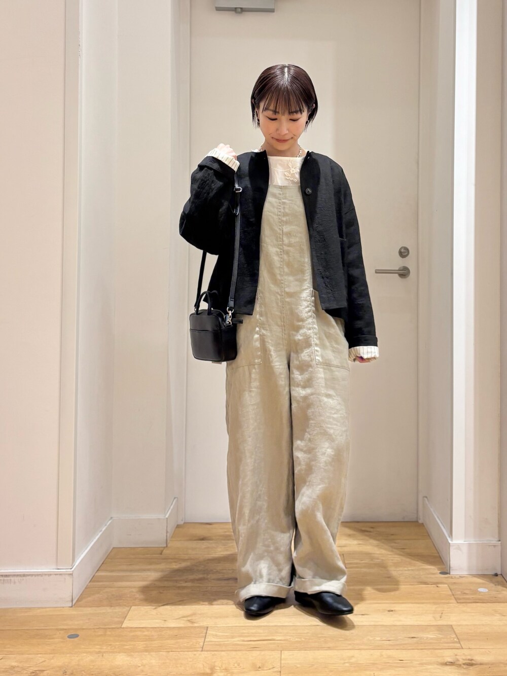 ホワイト系のシャツ/ブラウス、グレー系のサロペット/オーバーオール、ブラック系のその他シューズを着用したレディースの春コーディネートの4枚目の写真