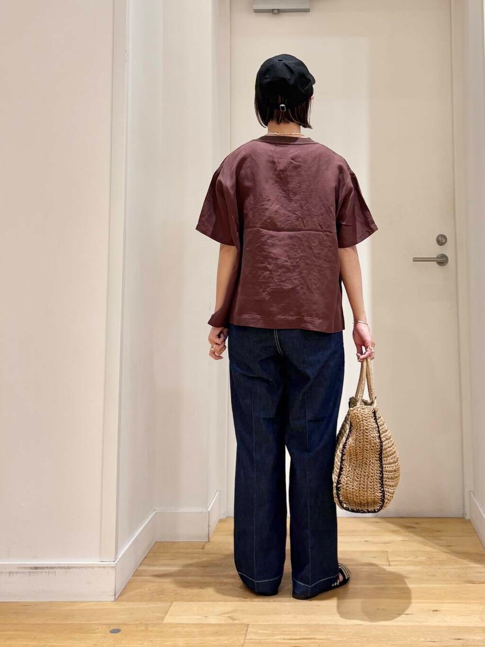 ベージュ系のトートバッグ、ブルー系のデニムパンツ、ブラック系のサンダルを着用したレディースの夏コーディネートの6枚目の写真