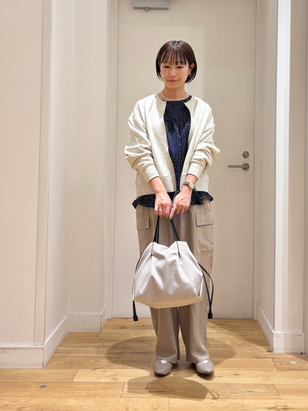 ホワイト系のカーディガン/ボレロ、ブルー系のシャツ/ブラウス、ベージュ系のその他パンツを着用したレディースの春コーディネートの2枚目の写真