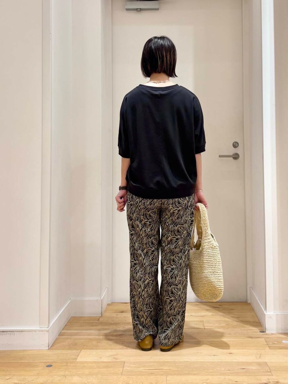 ベージュ系のトートバッグ、イエロー系のサンダル、グレー系のその他パンツを着用したレディースの夏コーディネートの6枚目の写真