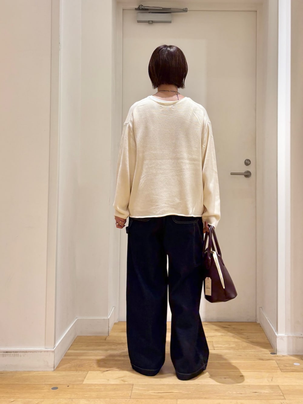 ホワイト系のニット/セーター、ブルー系のデニムパンツ、ベージュ系のその他シューズを着用したレディースの秋コーディネートの7枚目の写真