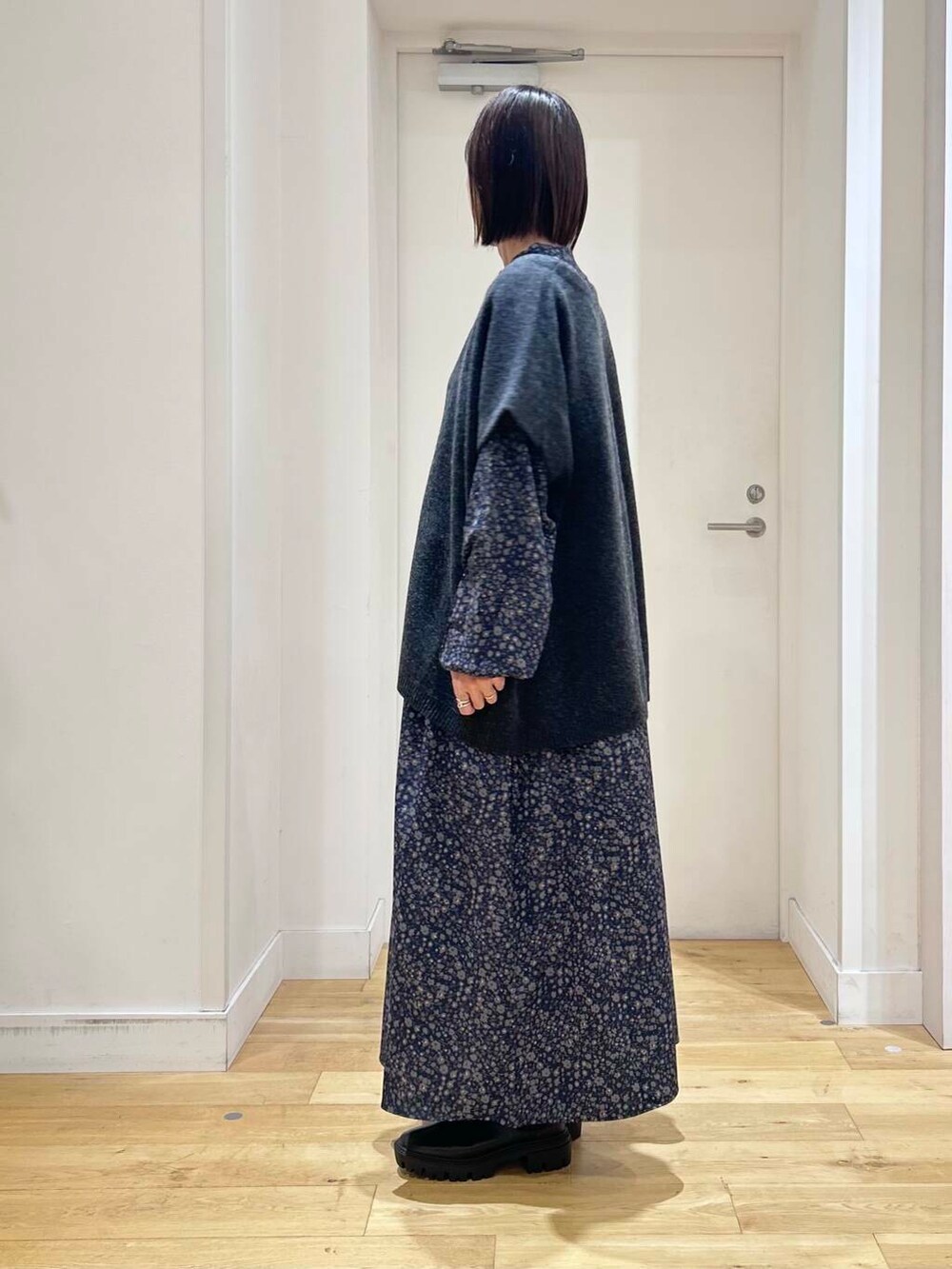 ブラック系のブーツ、ベージュ系のハンドバッグ、ブルー系のワンピースを着用したレディースの冬コーディネートの5枚目の写真