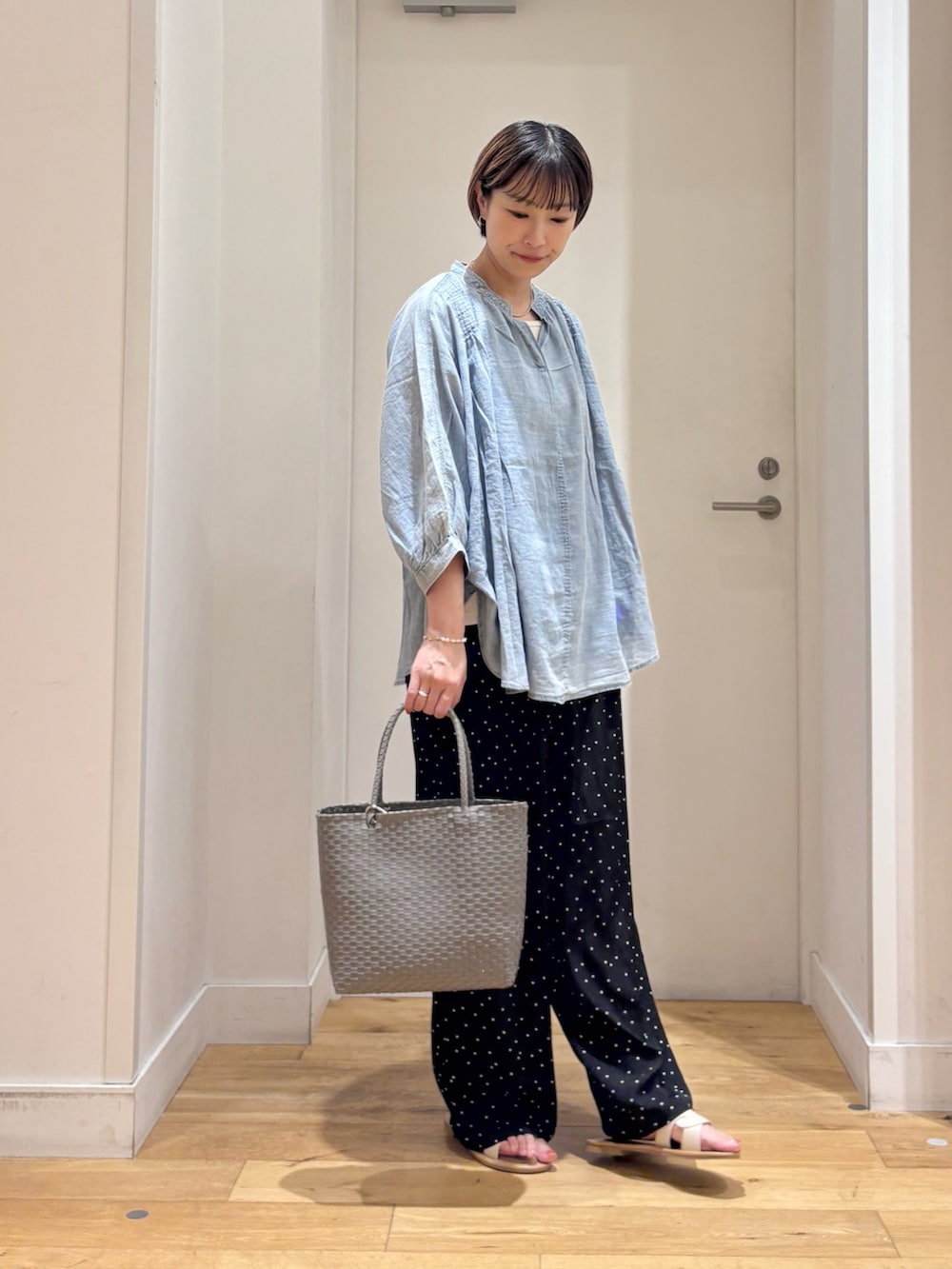 ブラック系のその他パンツ、グレー系のかごバッグ、ホワイト系のサンダルを着用したレディースの夏コーディネートの4枚目の写真