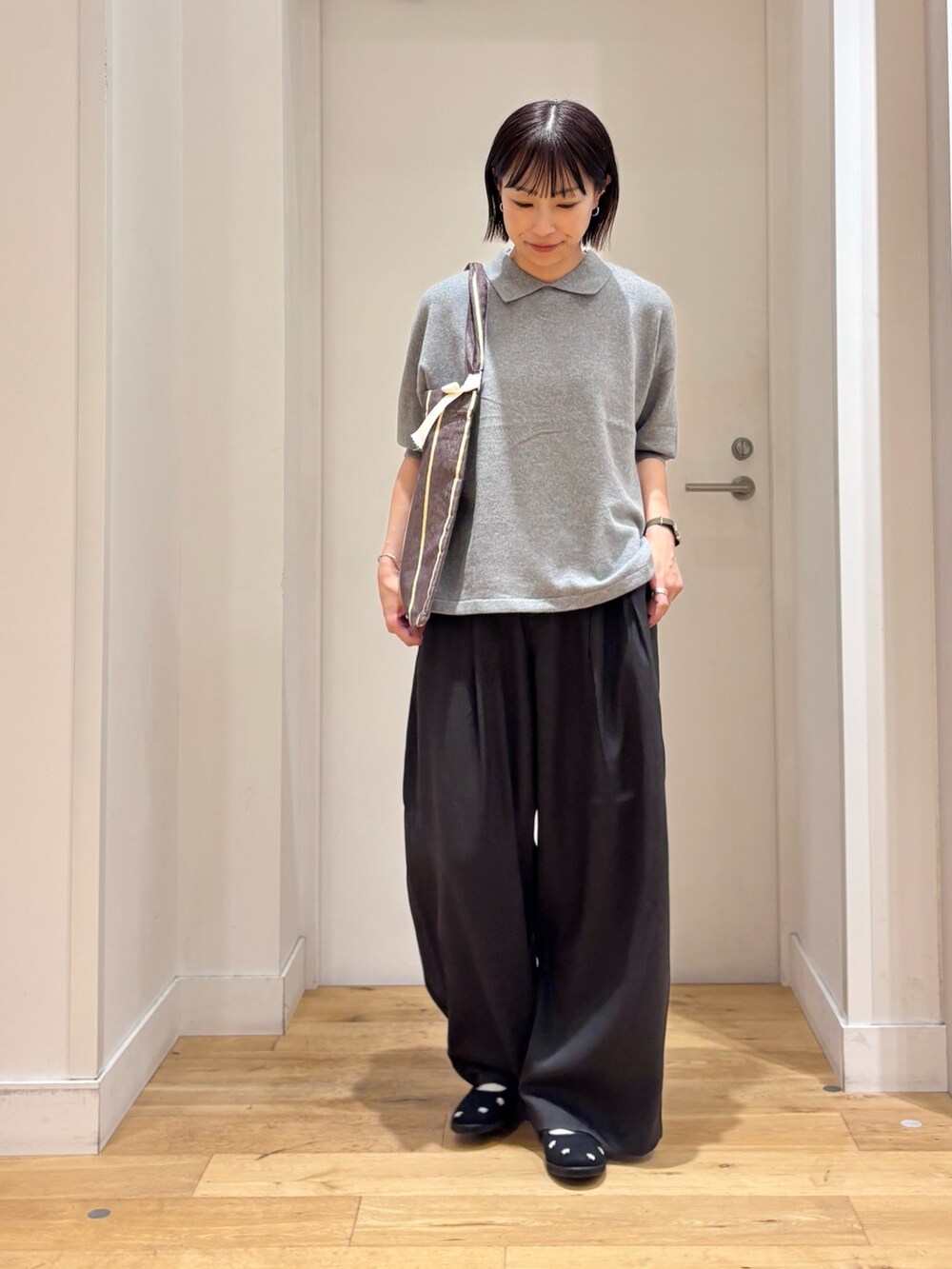 ブラック系のその他パンツ、グレー系のニット/セーター、ブラック系のスニーカーを着用したレディースの秋コーディネートの2枚目の写真