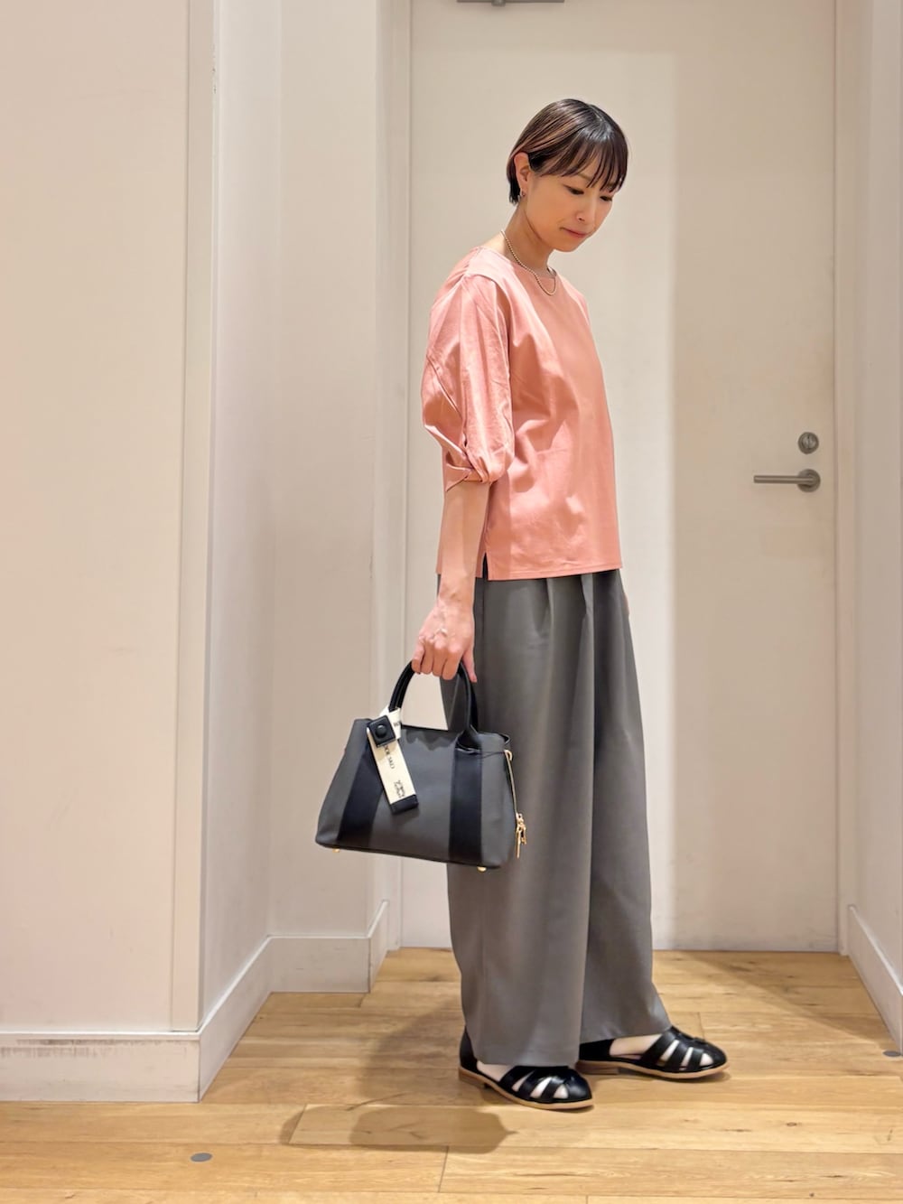ピンク系のTシャツ/カットソー、グレー系のその他パンツ、ブラック系のサンダルを着用したレディースの春コーディネートの5枚目の写真