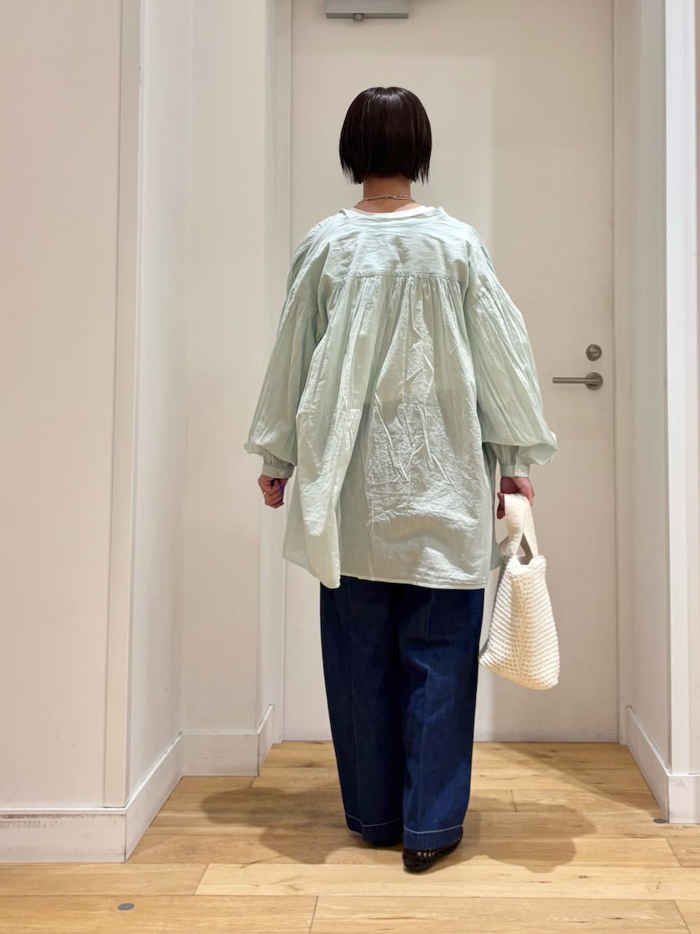 グリーン系のシャツ/ブラウス、ホワイト系のTシャツ/カットソー、ブルー系のデニムパンツを着用したレディースの春コーディネートの6枚目の写真