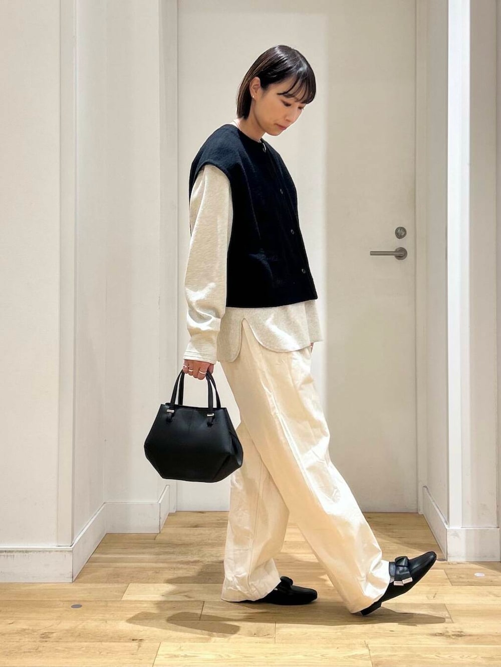 ブラック系のドレスシューズ、ベージュ系のデニムパンツ、ブラック系のショルダーバッグを着用したレディースの冬コーディネートの5枚目の写真