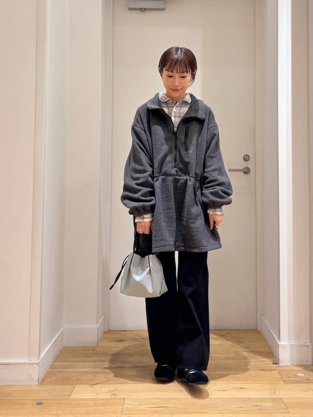 グレー系のスウェット、ブラック系のデニムパンツ、ホワイト系のシャツ/ブラウスを着用したレディースの秋コーディネートの4枚目の写真