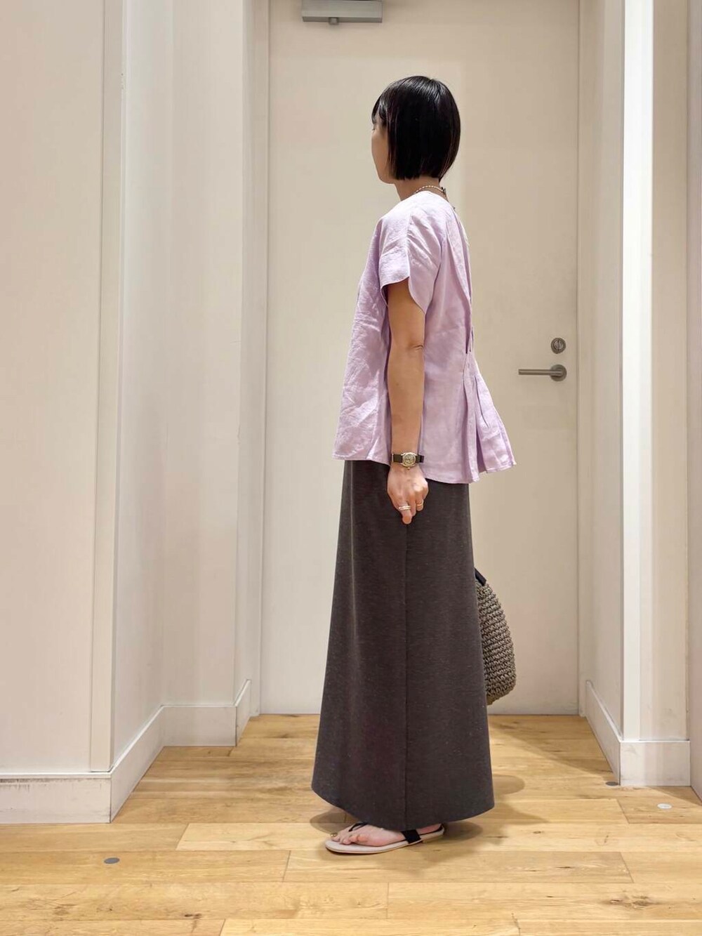 グレー系のトートバッグ、ブラック系のサンダル、グレー系のスカートを着用したレディースの夏コーディネートの4枚目の写真