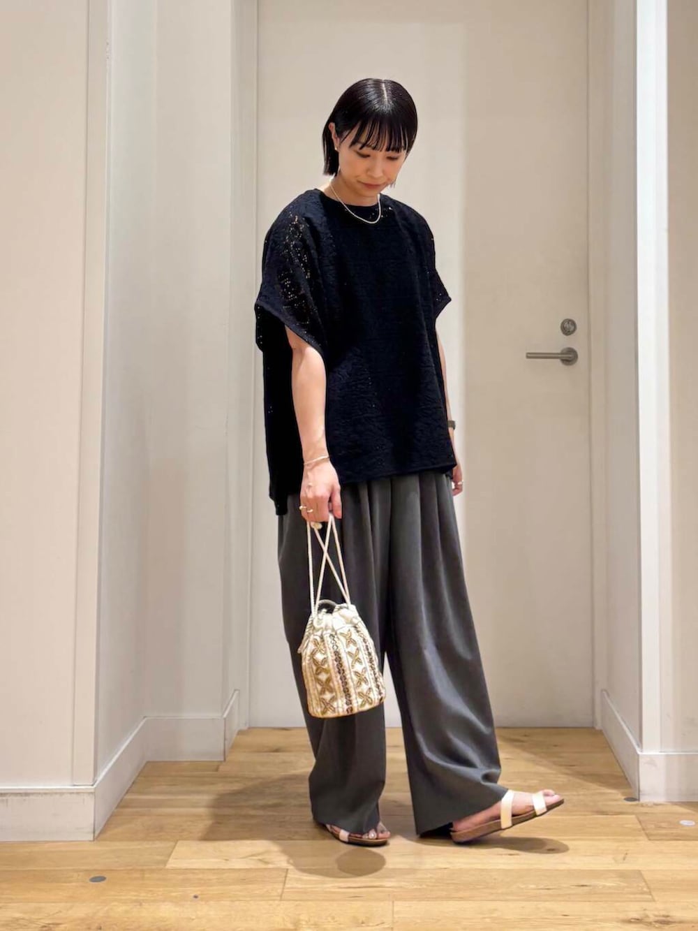 ホワイト系のショルダーバッグ、グレー系のその他パンツ、ホワイト系のサンダルを着用したレディースの夏コーディネートの4枚目の写真