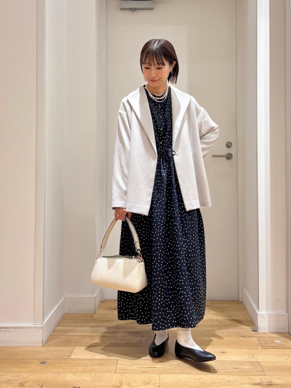 ブルー系のワンピース、グレー系のその他アウター、ホワイト系のショルダーバッグを着用したレディースの冬コーディネートの3枚目の写真