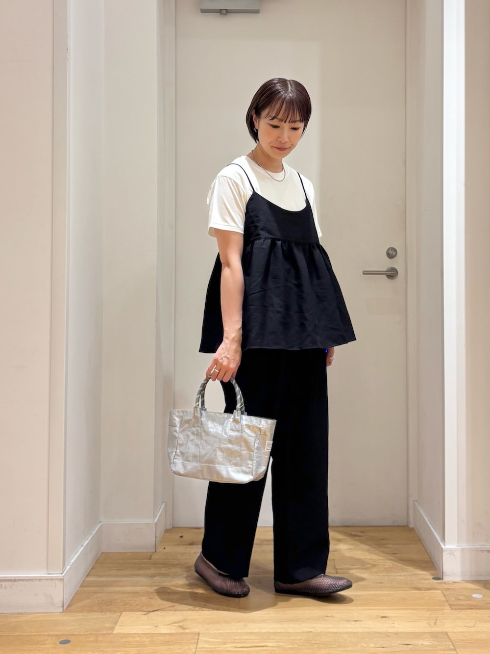 ブラック系のワンピース、ホワイト系のTシャツ/カットソー、シルバー系のショルダーバッグを着用したレディースの夏コーディネートの4枚目の写真
